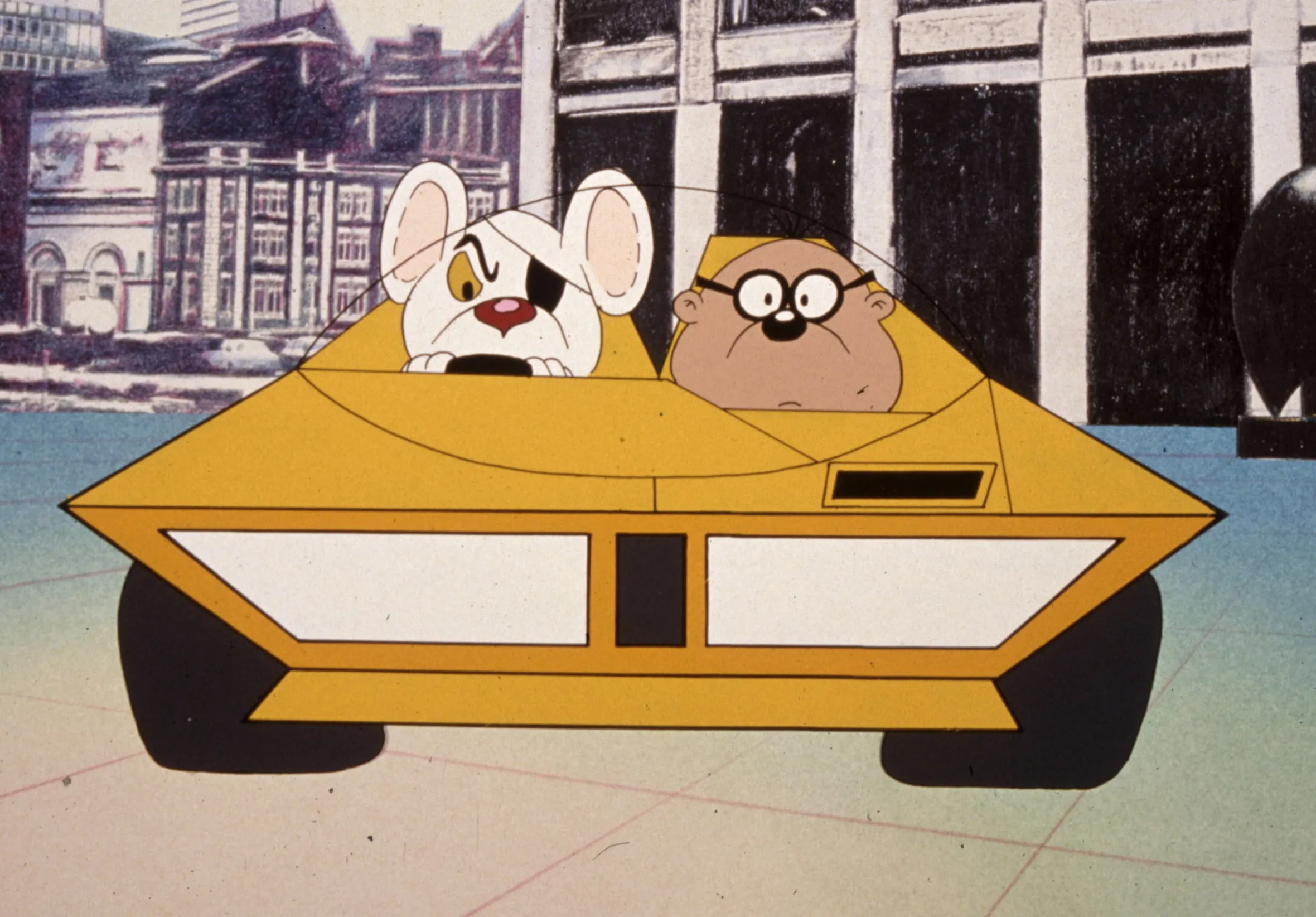 Illustration of Danger Mouse and Penfold in a yellow car with a city skyline in the background.