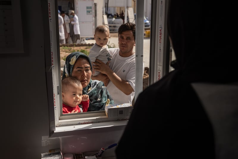 A mother and child get medicine from a United Nations-run pharmacy at a reception centre for refugees returning from Iran, in the border town of Islam Qala, Afghanistan. Photograph: Jim Huylebroek/The New York Times             
