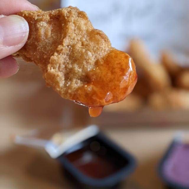 Chicken nugget being dipped in sauce