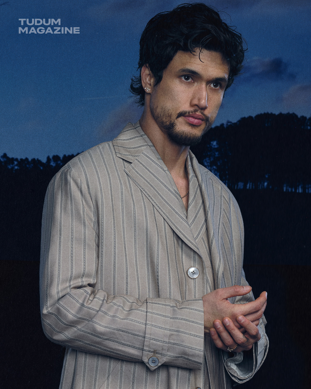 Charles Melton in a beige striped stuit