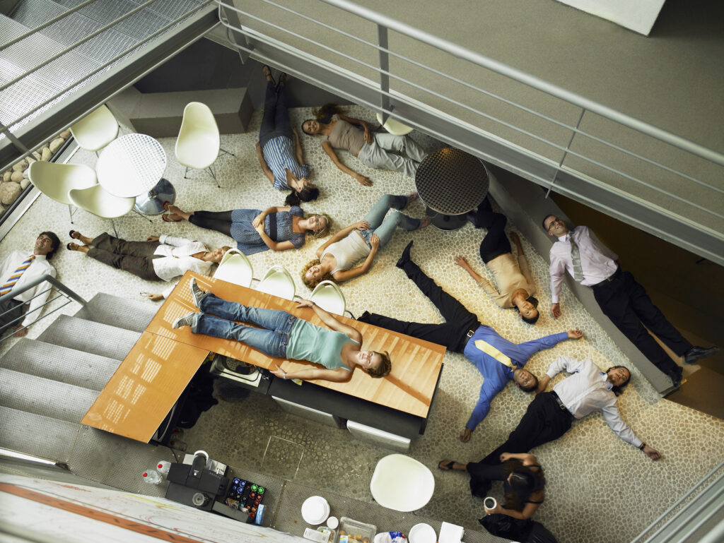 Businesspeople lying on the floor in an office.