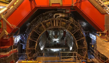 A metal semicircle structure wit lots of wires and a red structure above.