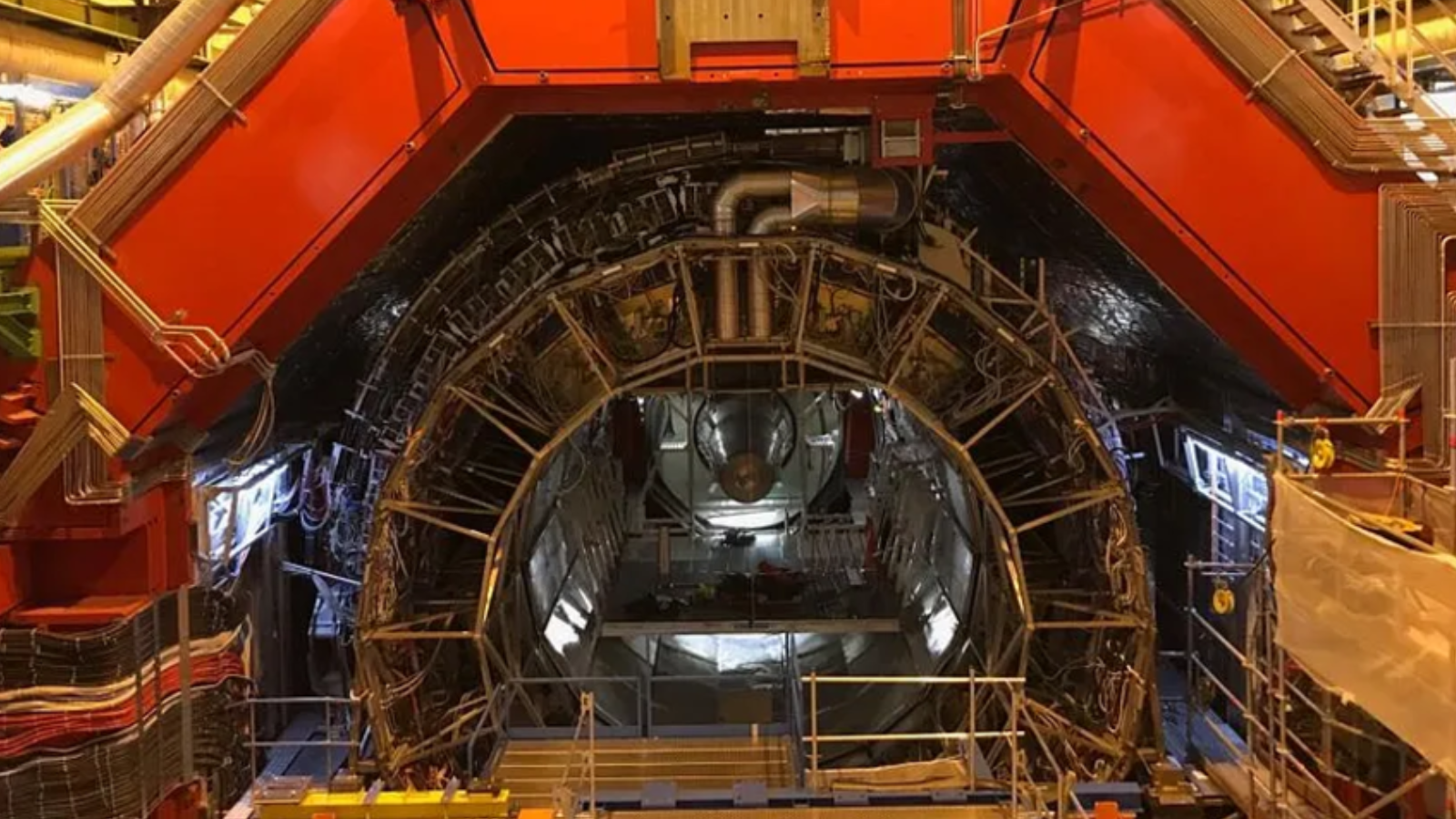 A metal semicircle structure wit lots of wires and a red structure above.