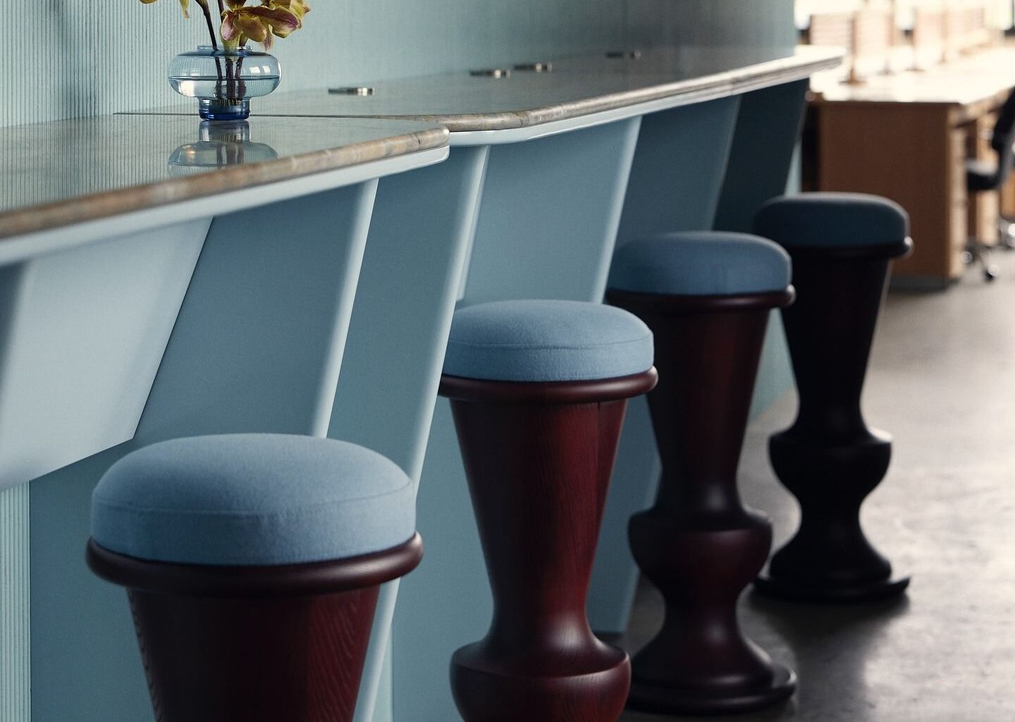 Image of a light blue bar with light blue and dark cherry wood bar stools.