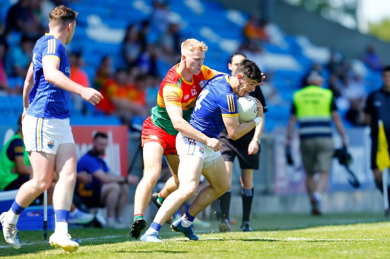 Dylan Farrell of Longford holds on to the ball under pressure from Carlow's Ross Dunphy, Tailteann Cup, 2023. Photograph: Ashley Cahill/Inpho