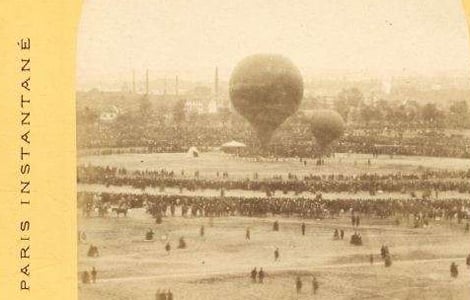 Sepia-toned historical photo of a large crowd gathered around two hot air balloons preparing for takeoff in an open field. "Paris Instantané" is written vertically along the left edge.