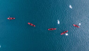 A sea kayak floating in the icy blue waters of Svalbard, Norway, near a rocky coastline