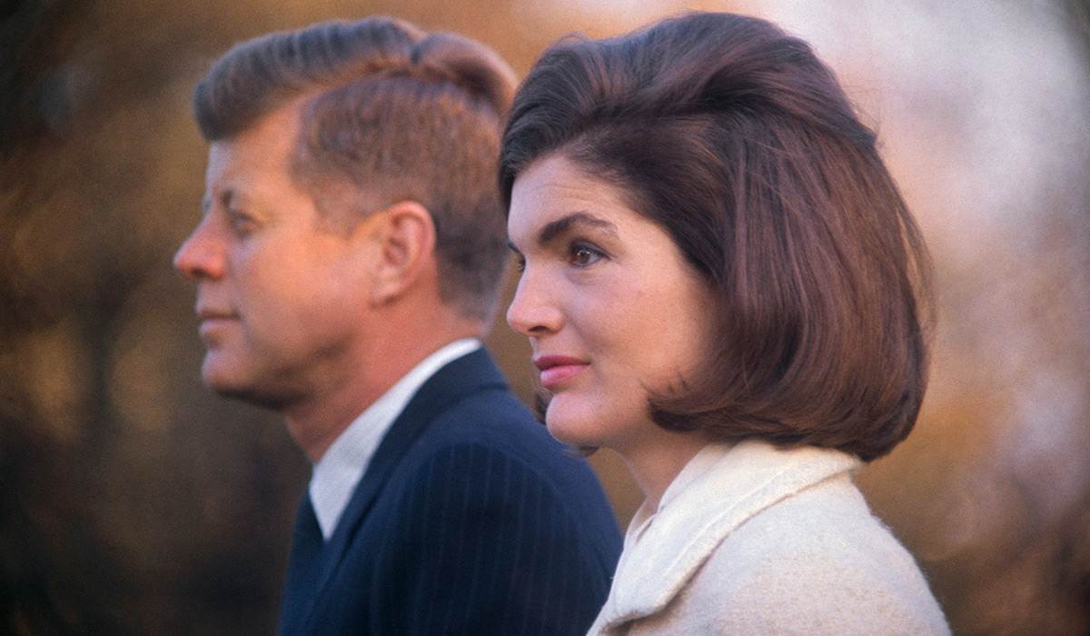 (Original Caption) President and Mrs. Kennedy are shown on the White House lawn as they witnessed part of the performance of the Black Watch Royal Highland Regiment. The Kennedys had invited 1,700 children, from child care agencies, to view the program.