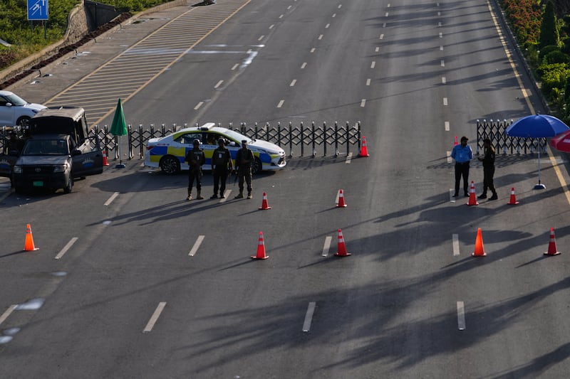Paramilitary soldiers and police officers stand guard at a checkpoint on a barricaded road for the US and Iran talks (Anjum Naveed/AP/PA)