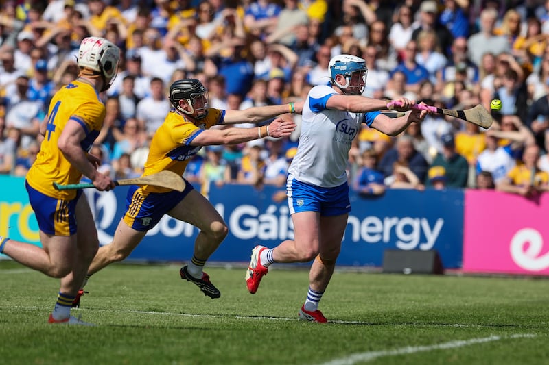 Stephen Bennett scores a goal despite the attention of two Clare players in Waterford's Munster opener. Photograph: Natasha Barton/Inpho