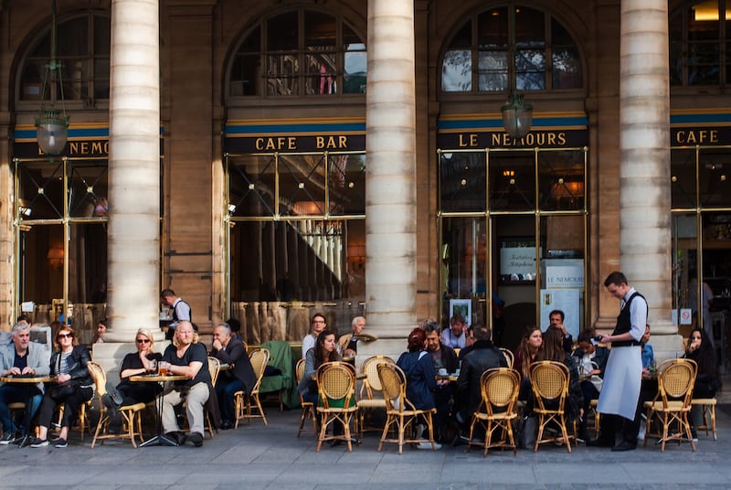 Tourists aplenty sit on the street outside a cafe in Paris. Photograph: Getty