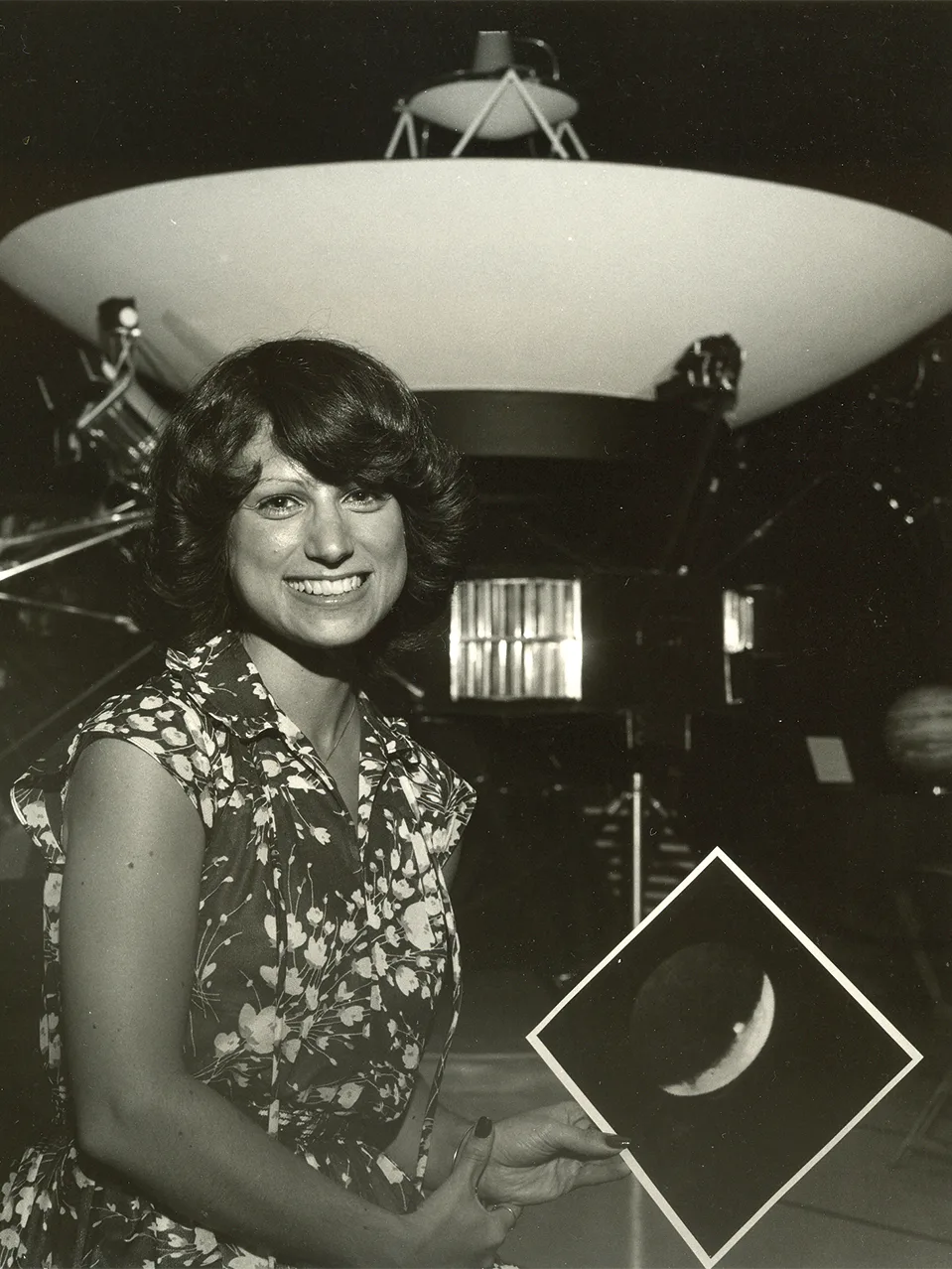 Linda Morabito pictured after her discovery of Io volcanism, in front of a model of the Voyager spacecraft at NASA's Jet Propulsion Laboratory. Morabito is holding a print of the image that enabled her to make the discovery. Credit: NASA
