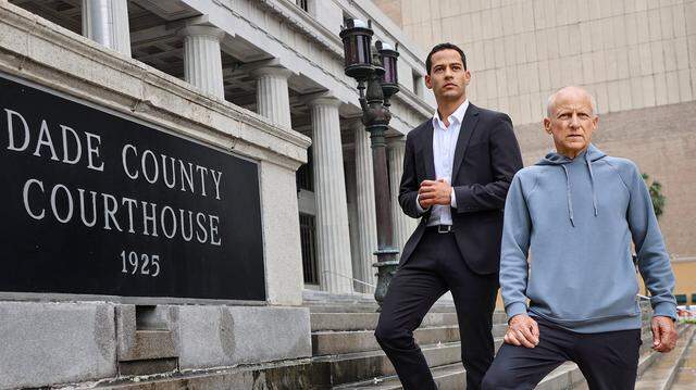 Pablo Langesfeld, left, who lost his daughter and son-in-law in the 2021 Champlain Towers collapse, stands with his son Martin, right, outside the old Dade County Courthouse in Miami, Tuesday, April 7, 2026. Langesfeld, now battling advanced pancreatic cancer, is suing Oscar Health Insurance for denying coverage of a drug therapy his doctors recommend, underscoring broader struggles over access to treatment.