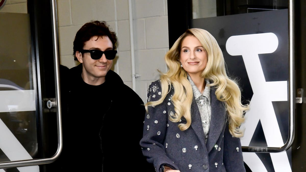 Meghan Trainor and her husband walk out onto an NYC street