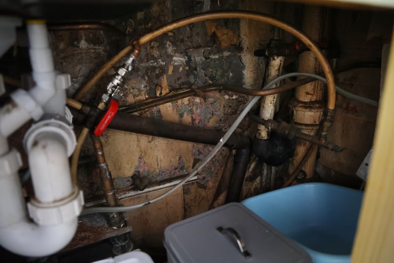 Damp and mould under the kitchen sink of Eileen Nalty's flat at Pearse House. Photograph: Bryan O’Brien
