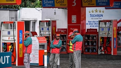 Workers wait for customers at a fuel station after the government raised fuel prices in Islamabad. (AFP)