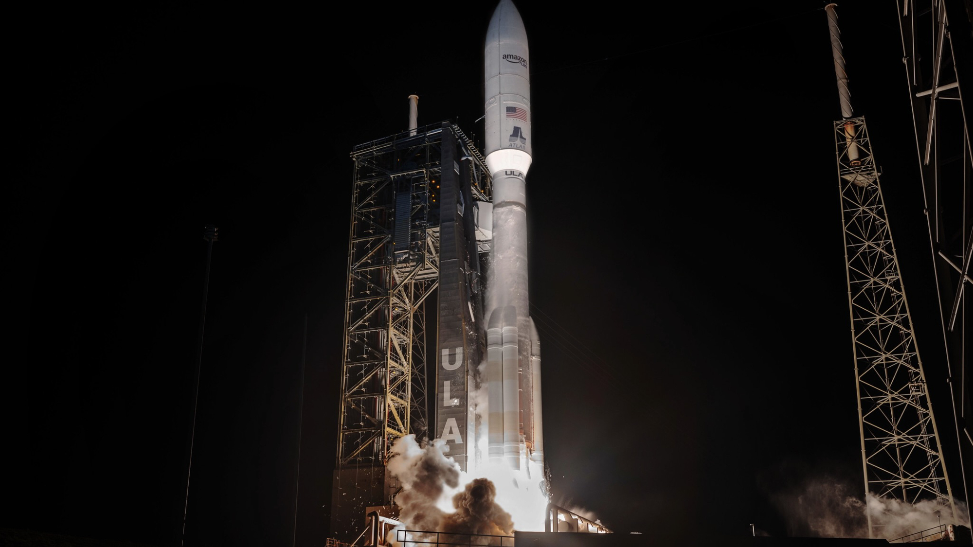 a big white rocket launches into a dark night sky