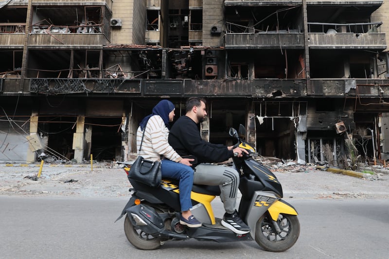 People drive past damaged buildings in the southern suburbs of Beirut, Lebanon, on Friday. Photograph by Wael Hamzeh/EPA