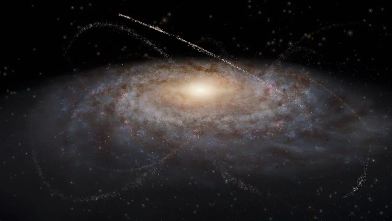 An artist&rsquo;s impression of streams of stars around a galaxy. The galaxy occupies most of the image as a fuzzy blue-white oval with spiral features extending out clockwise. The light clouds are interspersed with small dark brown splotches in the same spiral pattern around the center, representing dust clouds. The galaxy&rsquo;s center is a bright yellow glow. Overlaid on top of and surrounding the galaxy are several criss-crossing, faint tendrils of stars that represent satellite dwarf galaxies and star clusters that have been stretched out into long thin lines. The tendrils have various lengths and widths, though all are arcs rather than complete circles. The background is black.