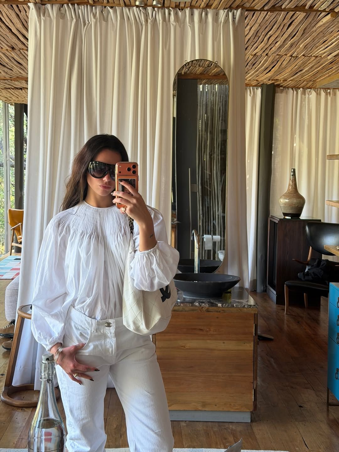 Image may contain Clothing Sleeve Blouse Chair Furniture Adult Person Accessories Bag Handbag Head Face and Sink