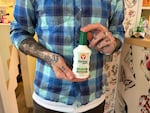 Sean Lanusse holds a bottle of Bactine MAX, an over-the-counter anesthetic that many tattoo artists use, in Thunderbird Tattoo, the tattoo shop where he works in the St. Johns neighborhood of Portland. April 1, 2026.
