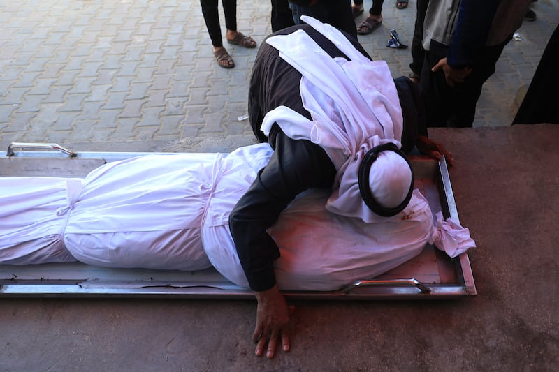 A Palestinian man kisses a shrouded body during the funeral of Palestinians who, according to a medic, were killed in an Israeli strike at al-Aqsa Martyrs Hospital in Deir al Balah in the central Gaza Strip. Photograph: Eyad Baba/AFP via Getty Images