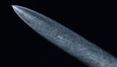 A streak of white shows a SpaceX rocket in the darkness of space.