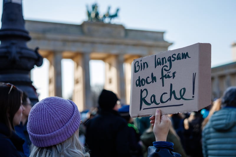 At a Brandenburg Gate rally in Berlin, a participant holds a placard that reads 'I'm slowly starting to feel like getting revenge!' Photograph: EPA