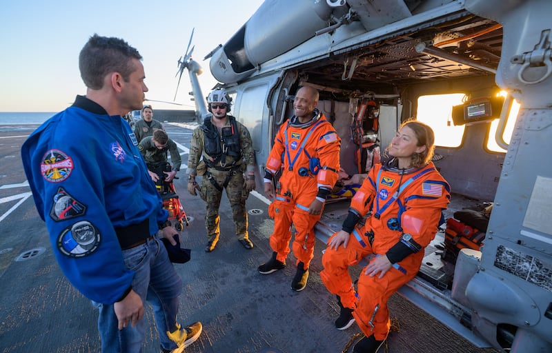 Nasa astronaut Victor Glover, Artemis II pilot, and Nasa astronaut Christina Koch, Artemis II mission specialist, talk with Jared Isaacman upon their return. Photograph: NASA/Bill Ingalls