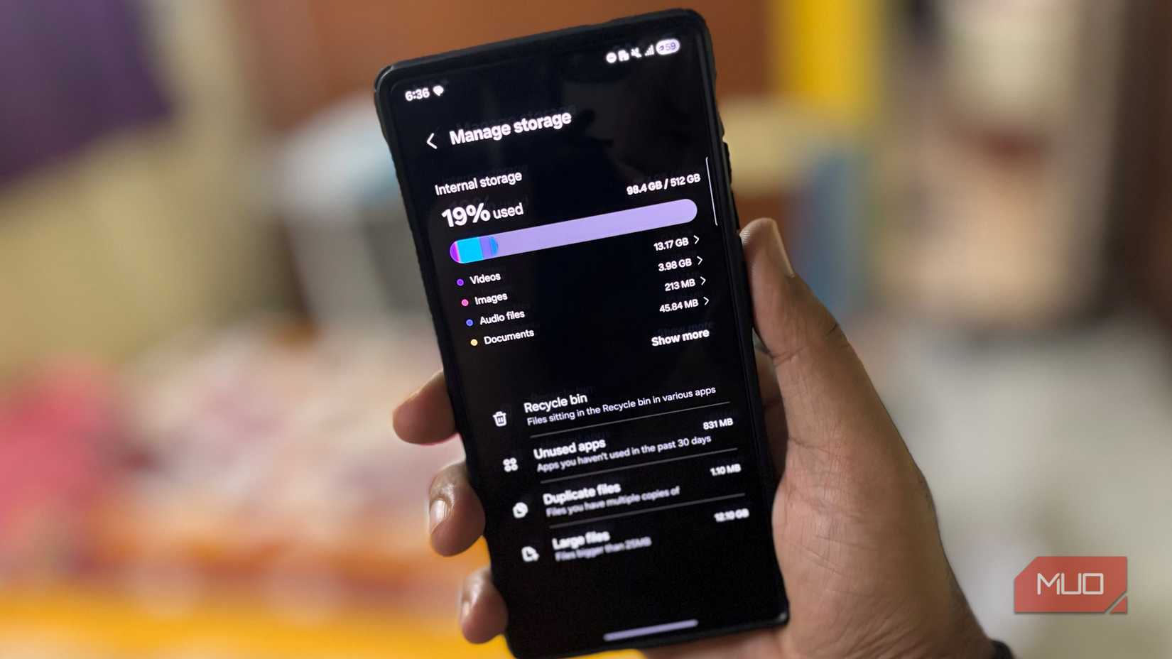 A man holds a Samsung phone and opens it to view the free and used storage space