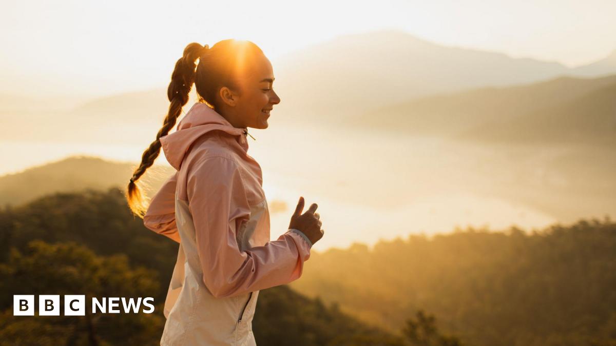 A woman takes a run in the early morning sunlight