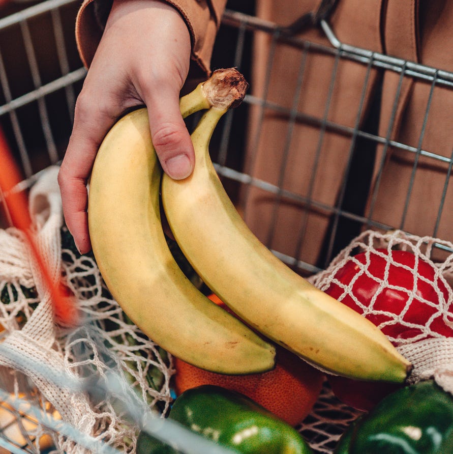 Young woman shopping vegetables in supermarket