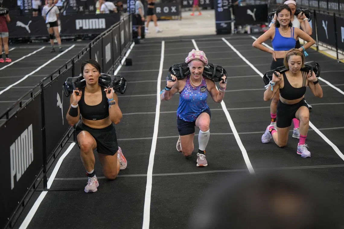 Carolyn Soemarjono (centre), a cancer survivor in her 60s, doing sandbag lunges during the Hyrox Singapore race held at the National Stadium on April 5, 2026.