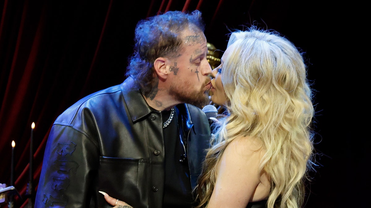 Jelly Roll and Bunnie XO kissing on stage.