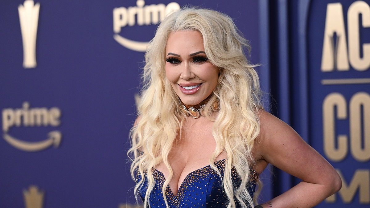 Bunnie Xo wearing a sleeveless royal blue dress at the Academy of Country Music Awards red carpet.