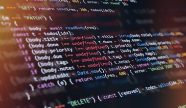 Close-up of computer screen showing colorful programming code lines with syntax highlighting and blurred light reflections.
