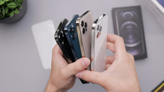 A person holds several smartphones. Photo from Unsplash