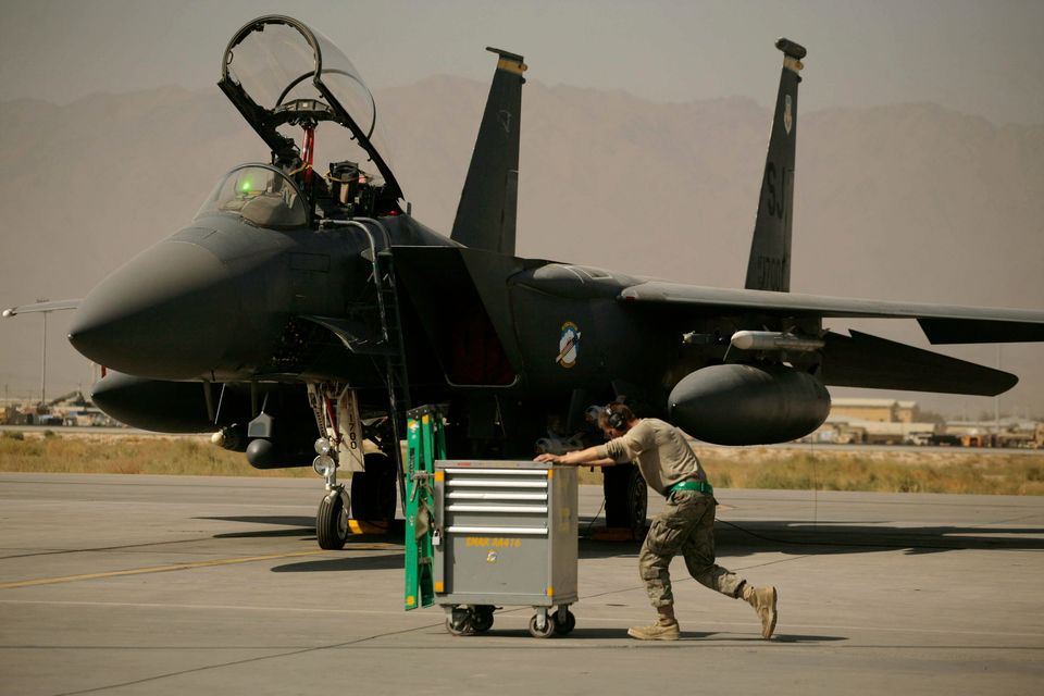 A US Air Force airman pushes a cart past an F-15E Strike Eagle at Bagram Air Field in Afghanistan (Maya Alleruzzo/AP)