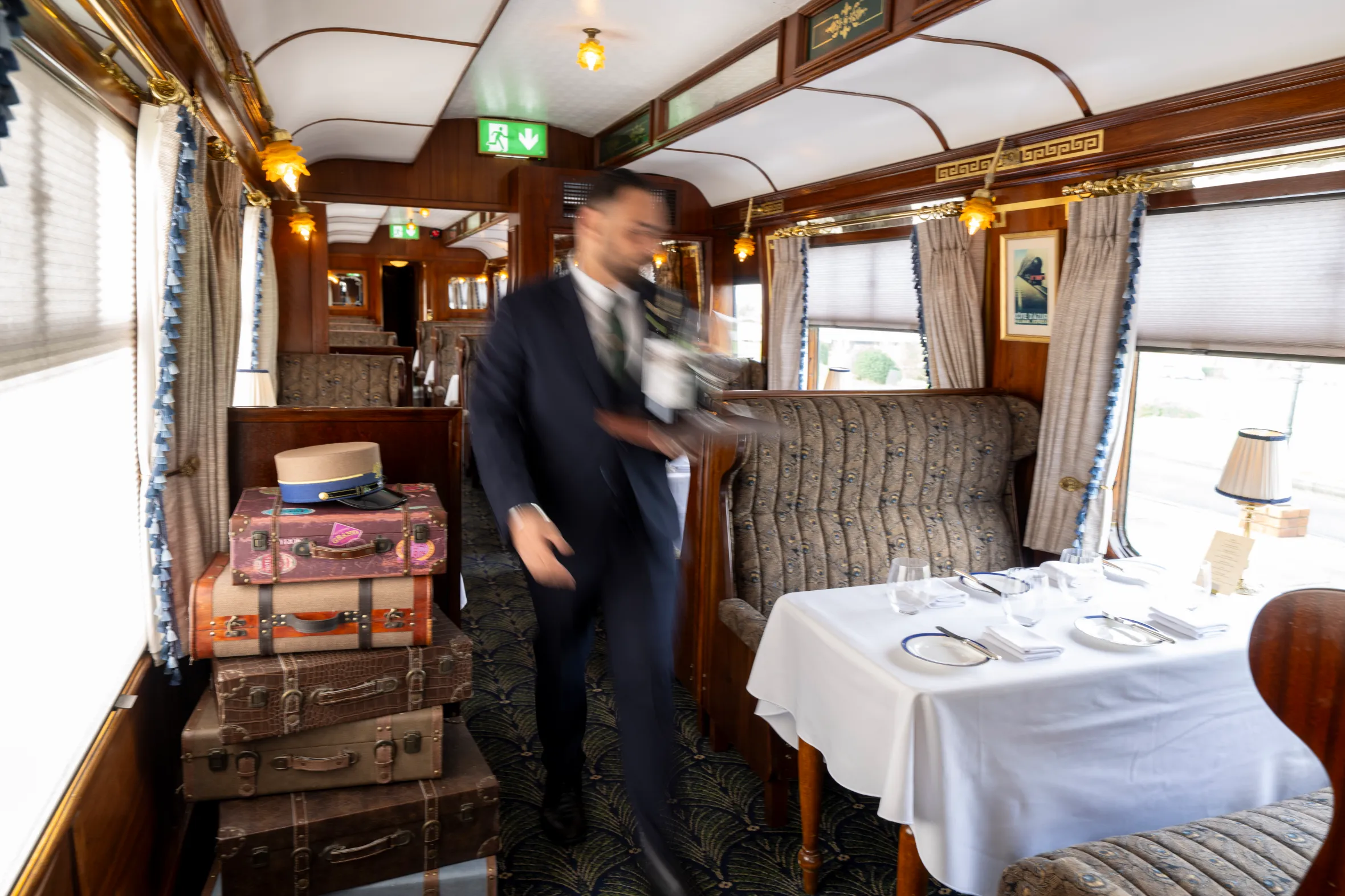 Angelo Vagiotis, Head Chef of The Pullman at Glenlo Abbey, walking through a luxurious train car dining room.