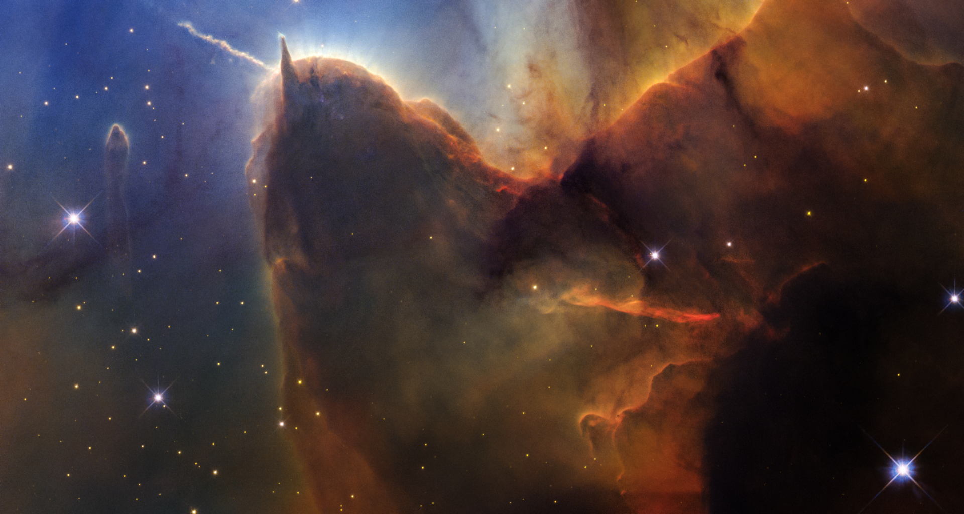 A rich, cosmic landscape is split in two. On the right side, clouds of reddish-black dust billow. On the left, stars sparkle across a dark-blue background.