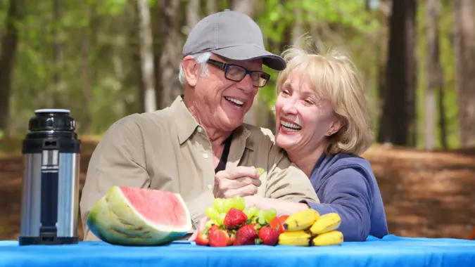 Smiling senior couple enjoying their time at a park for stock photo.