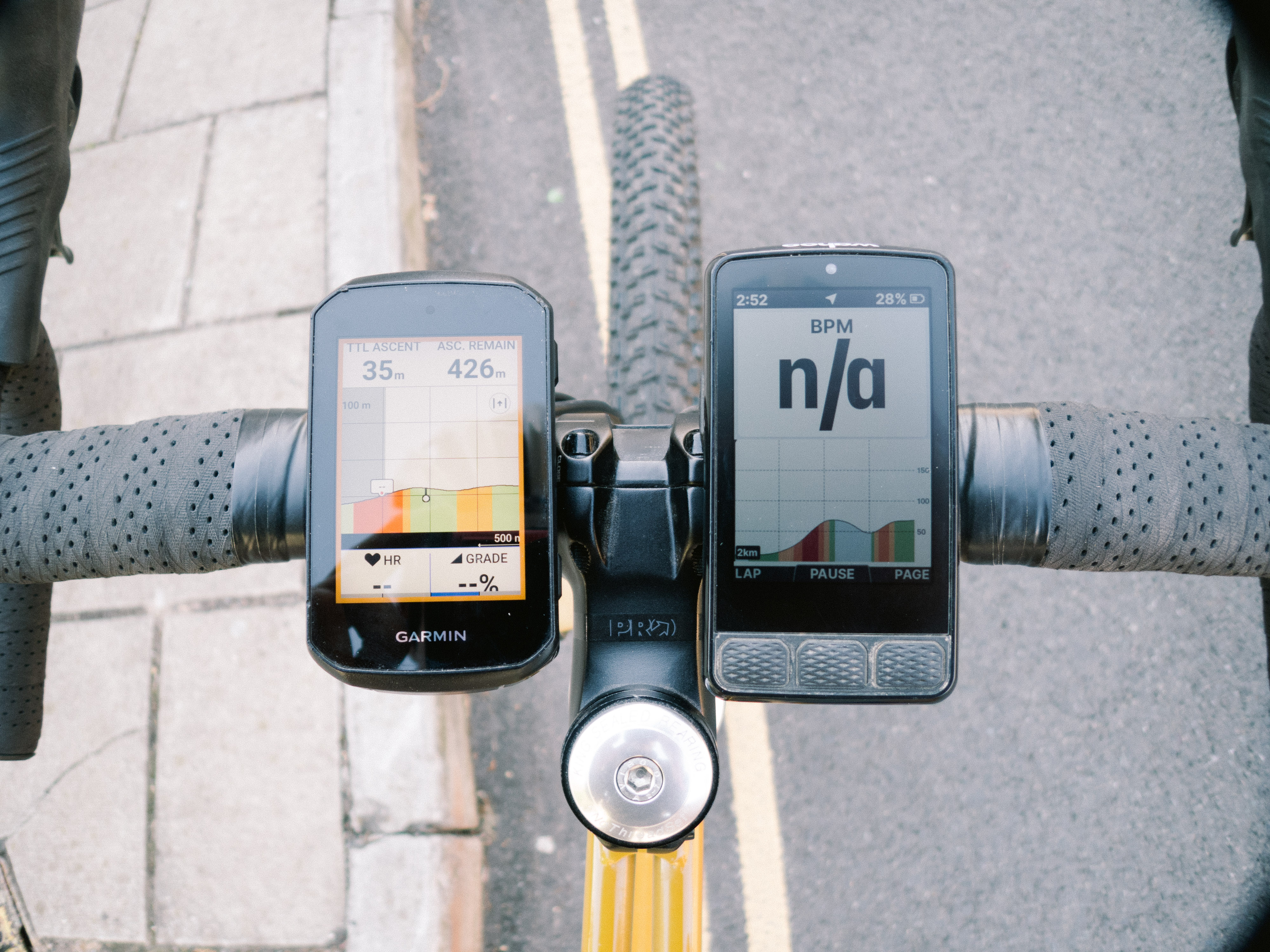 Two bike computers side by side on a gravel bike handlebar