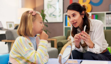 Mirror, speech therapy and cards with woman and girl for language assessment, sound and teaching. Tongue placement, child development and phonics exam with person and kid for education consulting