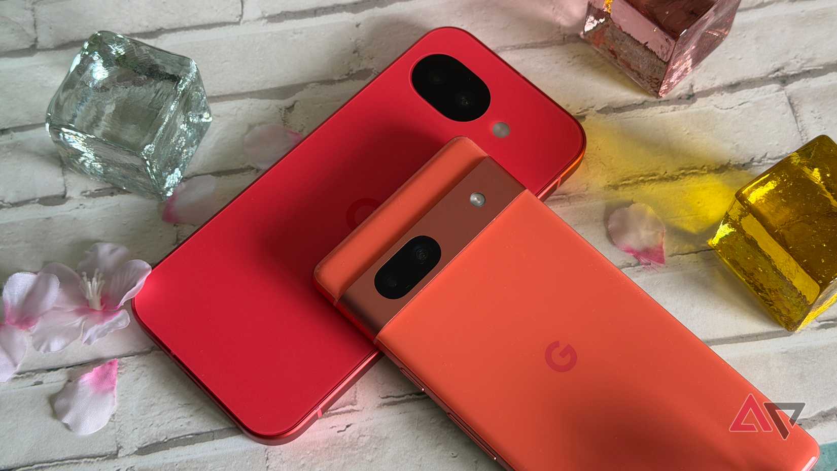 Google Pixel 10a and Pixel 7a surrounded by glass beads