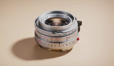 A close-up of a vintage camera lens with metallic and brass accents, engraved distance and aperture markings, and a beige background. The lens displays “7-ELEMENT” and measurement scales in red and black.