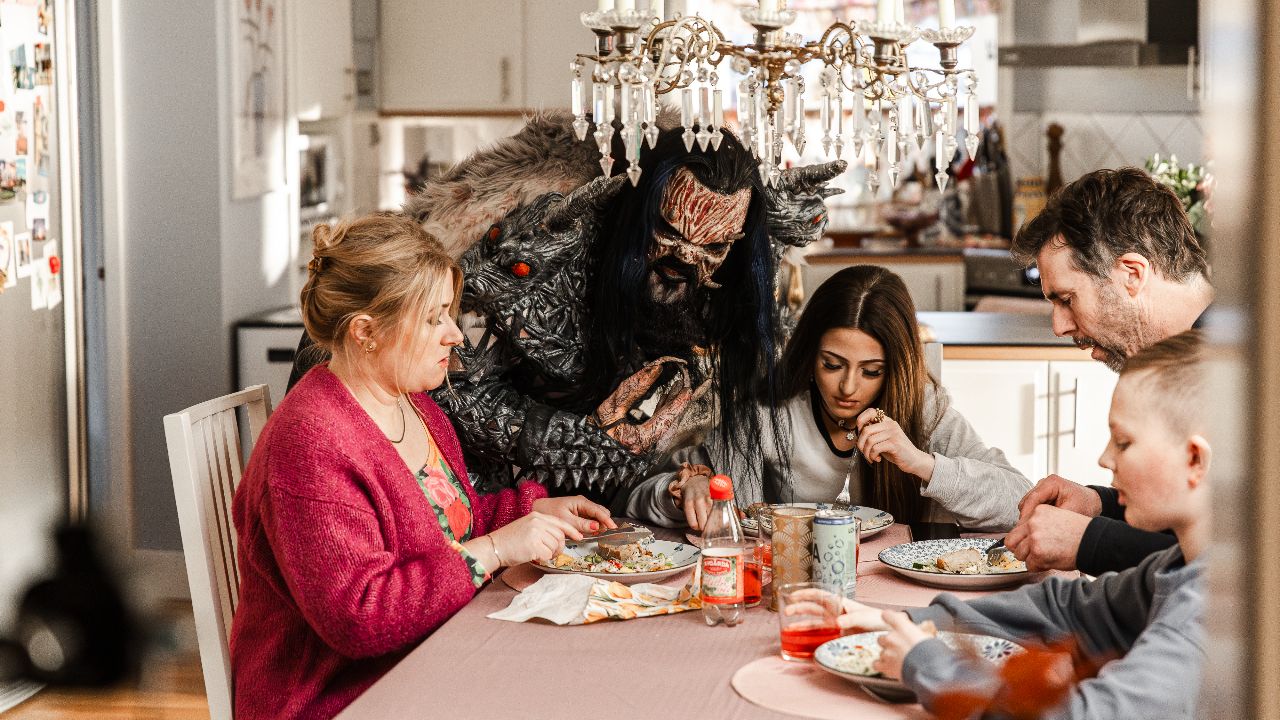 Mr Lordi at a table with a family eating food