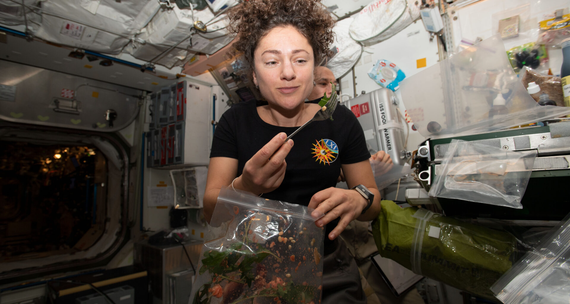 NASA astronaut Jessica Meir dines on fresh Mizuna mustard greens she harvested earlier that day aboard the International Space Station.