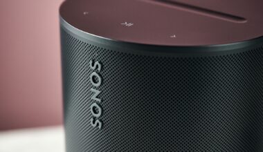 An even closer shot of the Sonos Era 100 SL, showing the Sonos logo on the front and the play/pause and skip buttons on top.