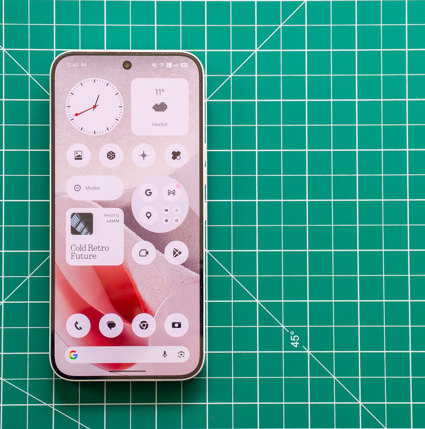 Photo of Nothing Phone 4A Pro on a green cutting mat showing the homescreen