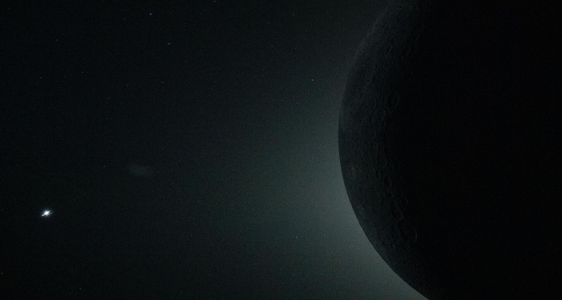 Close-up view from Orion spacecraft during the lunar flyby on April 6 captures a total solar eclipse, with only part of the moon visible as it obscures the sun. The object at left is Venus.